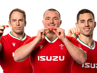 Three Welsh Rugby Union (WRU) players in red jerseys holding WRU OPRO mouthguards and smiling at the camera.