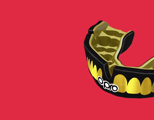 Black and gold OPRO mouthguard with fang design rotating on a red background.