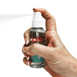 Hand holding a bottle labeled 'opro' against a white background