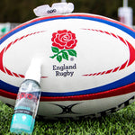 England Rugby ball with OPRO Clenaing spray on a grass field