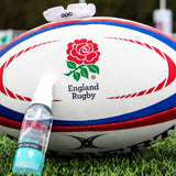 England Rugby ball with OPRO Clenaing spray on a grass field