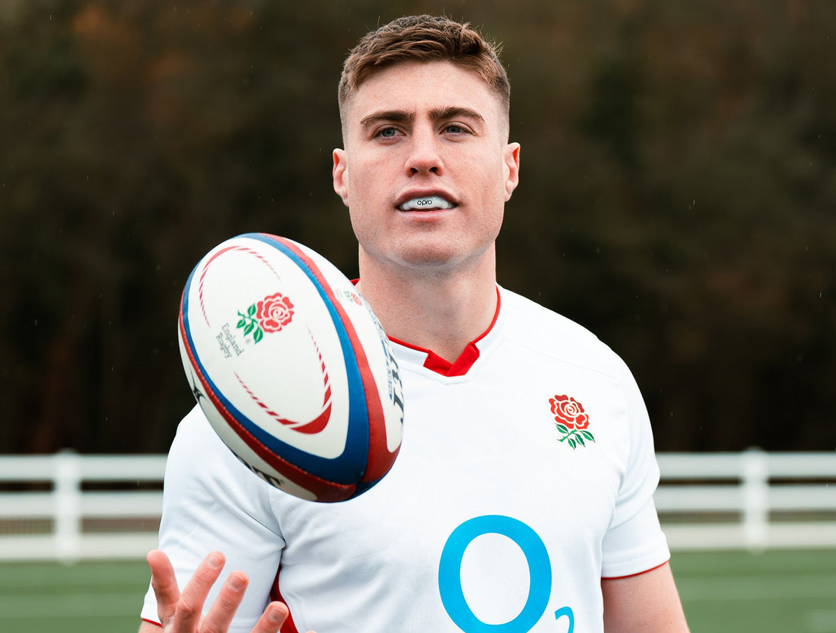 Man holding a rugby ball with a blurred background