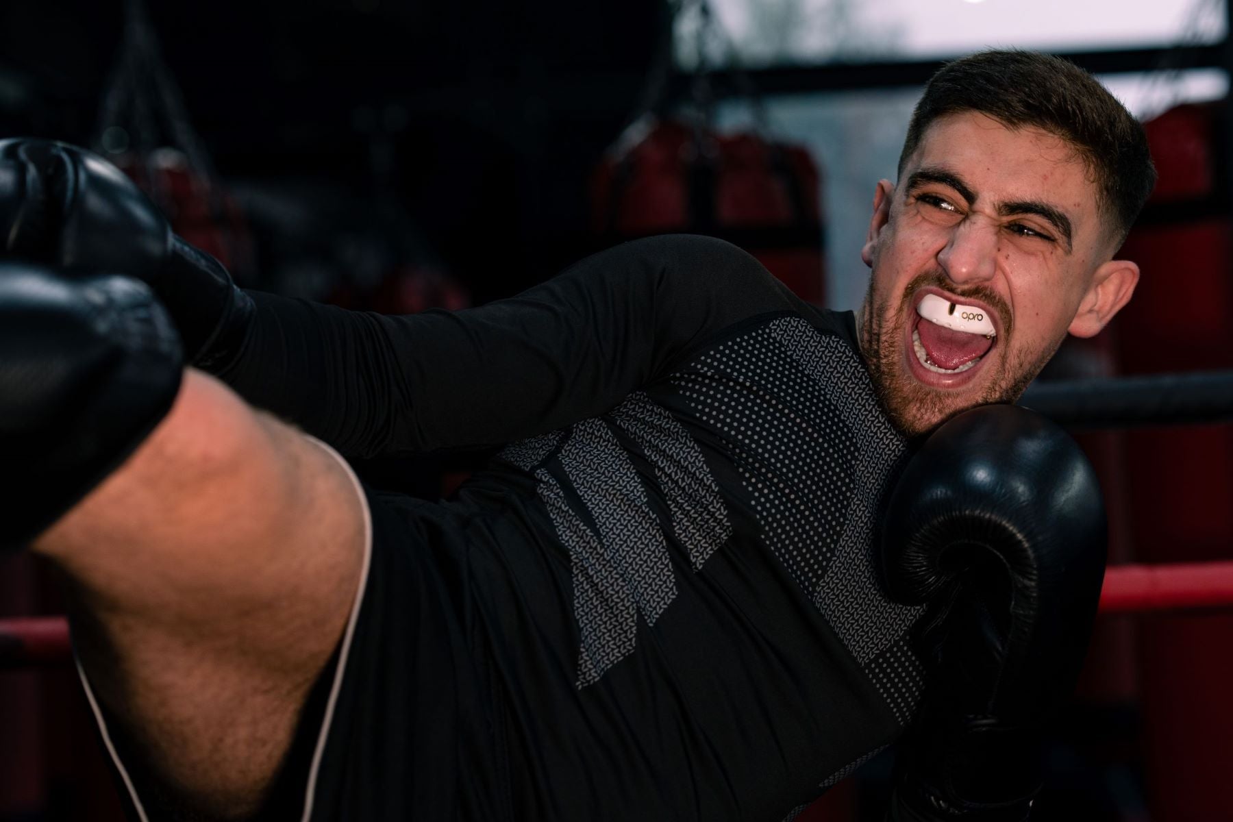 Kickboxer with gumshield delivering a kick